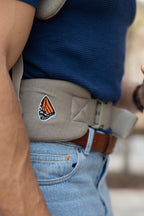 Waistband view of the Mabē Monarch Buckle Carrier in Charles Herringbone, which is a delicate herringbone weave cotton/linen fabric in shades of brown, worn by an unseen person.