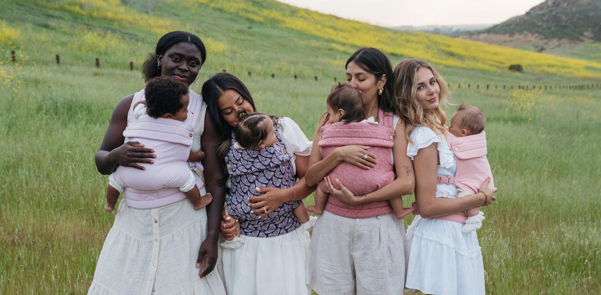 The Mabē Monarch Buckle Carrier worn by four women with babies